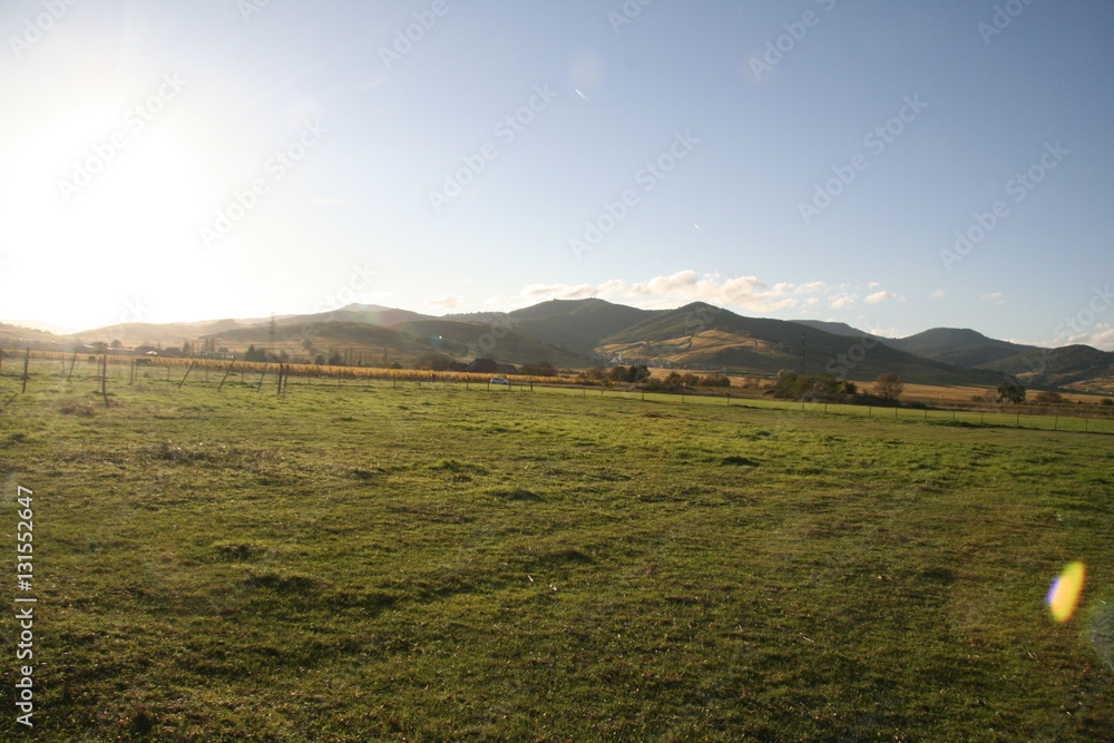Fototapeta premium Late sun on field and mountain