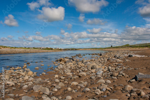 Sandy Beach with small river and traditional stone arched bridge in Lehinch on the Atlantic Coast in the West of Ireland