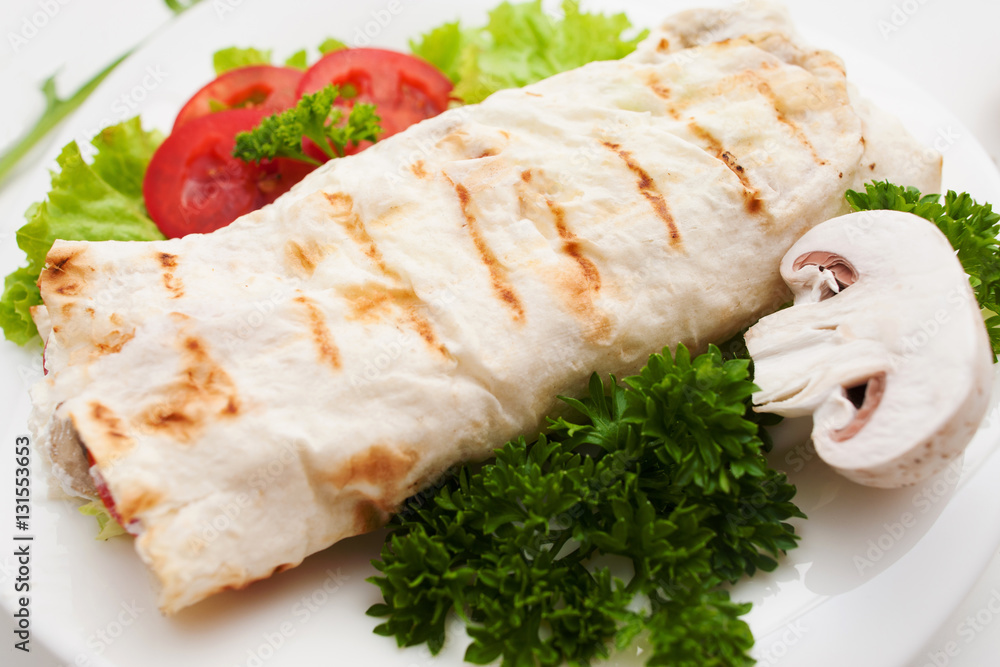 Burrito with fresh mushroom and parsley close up. Grilled shawarma served with vegetables. Turkish sandwich, mediterranean cuisine, junk food concept Burrito with fresh mushroom and parsley close up. Grilled shawarma served with vegetables. Turkish sandwich, mediterranean cuisine, junk food concept