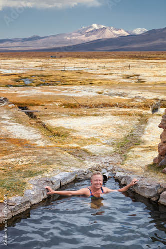 Tourist bathing in hot springs, Sajama national park, with volca photo