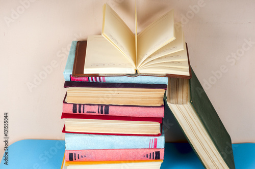 Open book  stack of colorful hardback books on light table. Back to school. Copy space for text