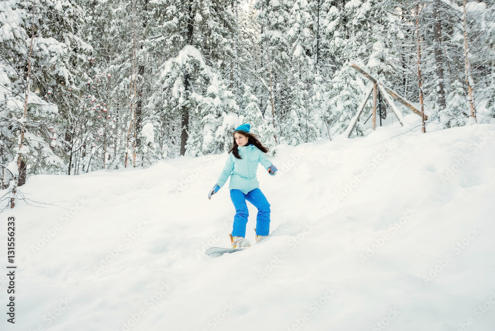 a girl riding on a snowboard in the woods