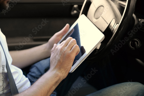 Young male driver using tablet computer, close up view