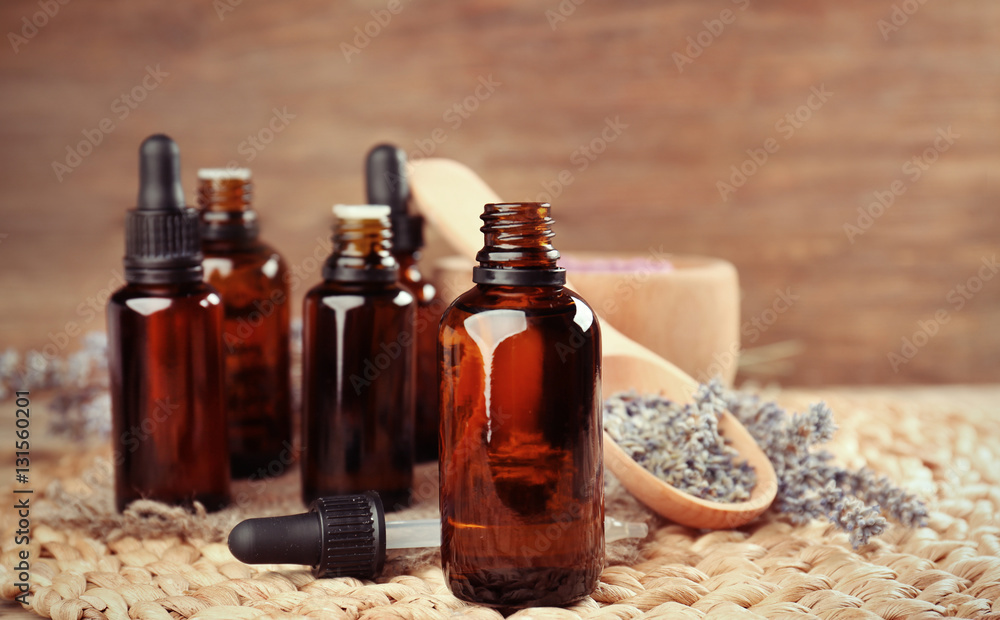 Essential oils and lavender on wooden background