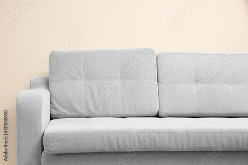 New cozy couch on light wall background