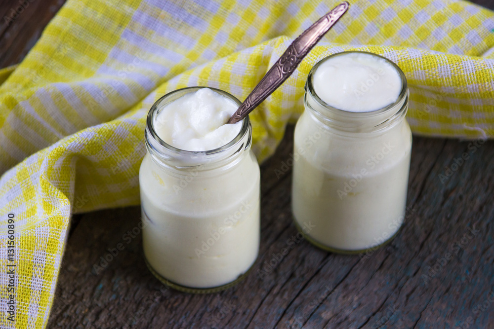 Homemade white yougurt with yellow napkin on the wooden table Homemade white yougurt with yellow napkin on the wooden table