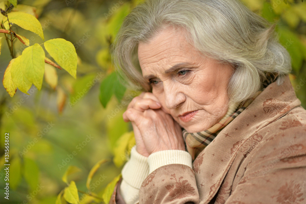 Sad elderly woman in autumn park Sad elderly woman in autumn park