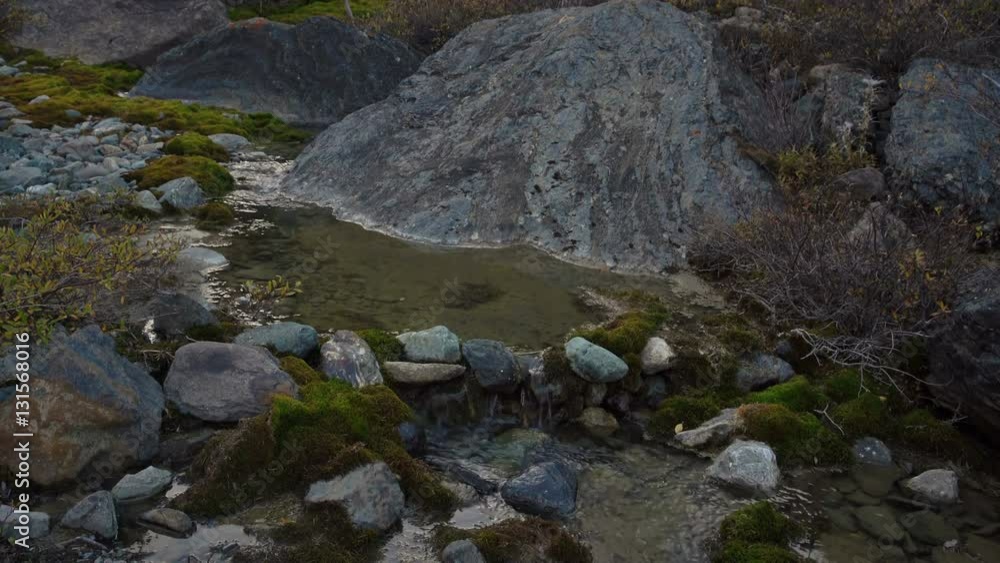 Small Calm Stream Flowing Between The Natural Rocks In Russian Sberia. Small Calm Stream Flowing Between The Natural Rocks In Russian Sberia.