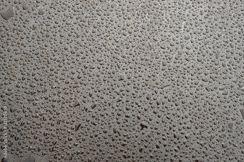 Wet grey asphalt covered with drops of water Wet grey asphalt covered with drops of water