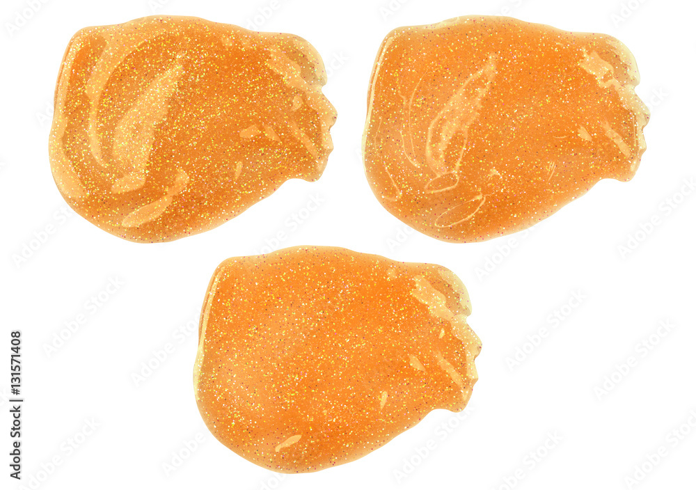 Three yellow smeared lip gloss samples with different lighting and reflections, isolated on white background, clipping paths included Three yellow smeared lip gloss samples with different lighting and reflections, isolated on white background, clipping paths included