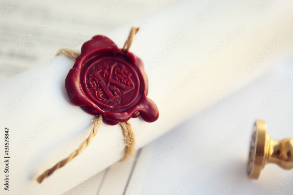 Tied scroll with old notarial wax seal and stamp on table Tied scroll with old notarial wax seal and stamp on table