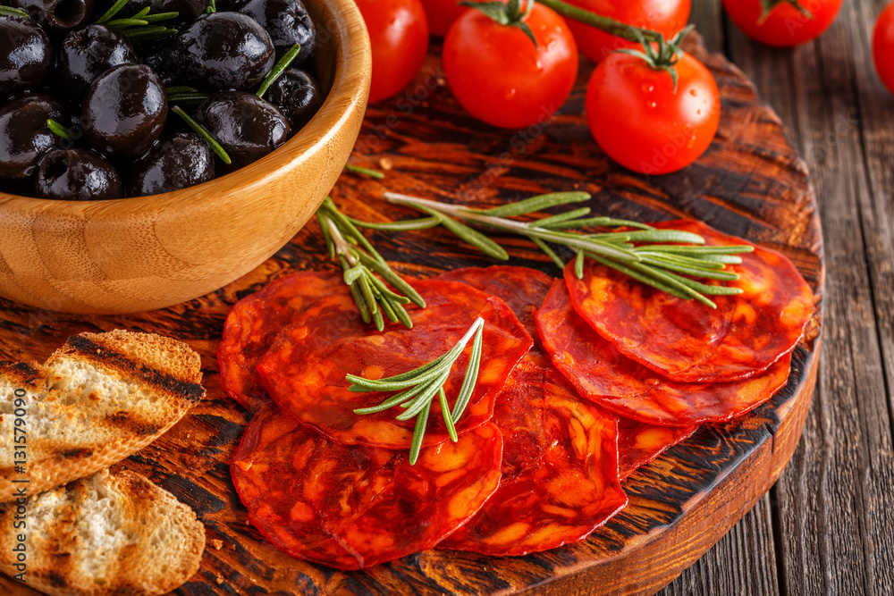 Spanish traditional chorizo sausage with fresh herbs, olives. Spanish traditional chorizo sausage with fresh herbs, olives.