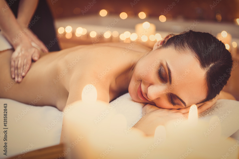 Obraz premium Cheerful girl enjoying body treatment at spa