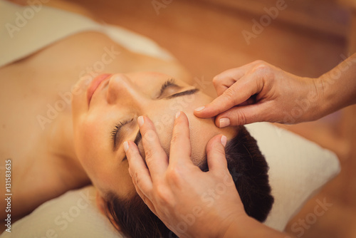 Beautician doing facial massage for client