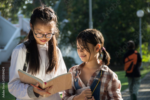 Girls reading book and smile with blurred background