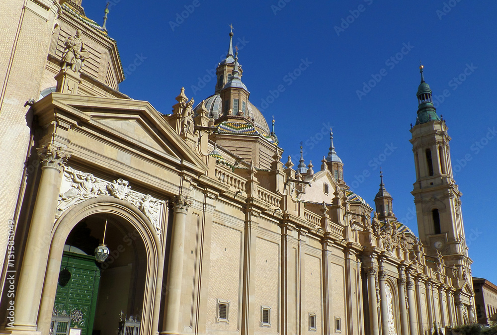 Gorgeous domes and towers of Cathedral-Basilica of Our Lady of the Pillar against vivid blue sky, Zaragoza, Spain 