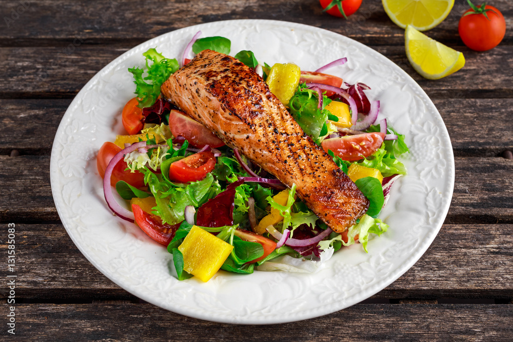 Fried Salmon steak with fresh vegetables salad. concept healthy food.