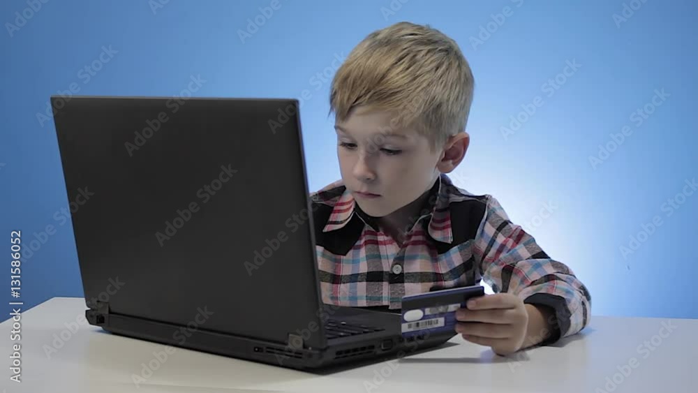 Cute little boy use laptop and credit card Cute little boy use laptop and credit card