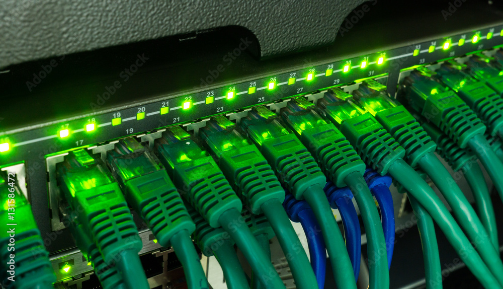 Network switch and ethernet cables glowing in server room