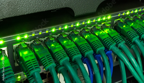 Obraz na płótnie Network switch and ethernet cables glowing in server room w salonie