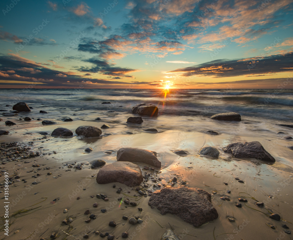 sunset over the sea beach,natural seascape, beach and cliff illuminated by the setting sun

