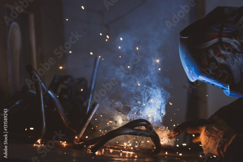 Welding work in a metalwork factory producing sparks and smoke