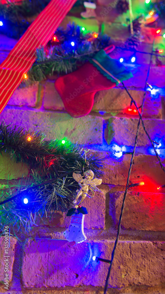 Fototapeta premium Christmas tree decoration over a brick chimney 
