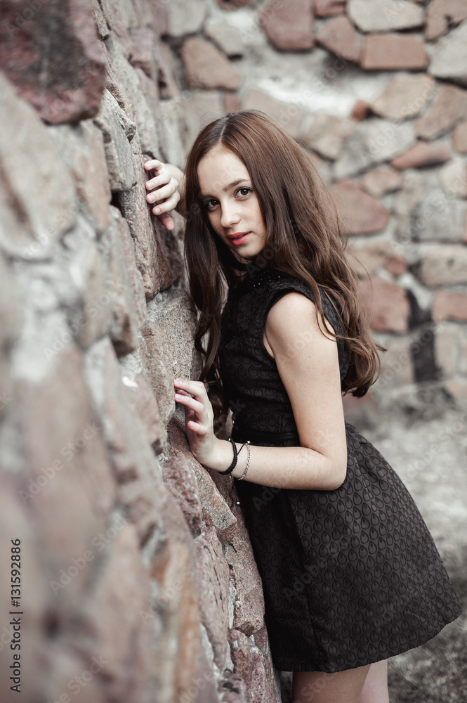 beautiful sad young woman on a stone wall background beautiful sad young woman on a stone wall background
