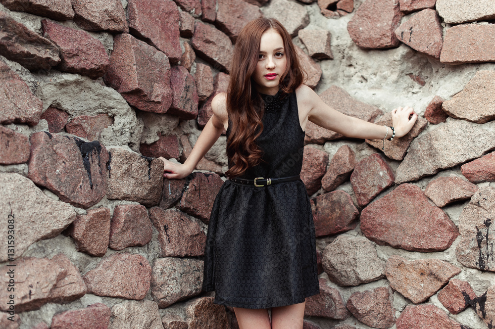 beautiful sad young woman on a stone wall background beautiful sad young woman on a stone wall background