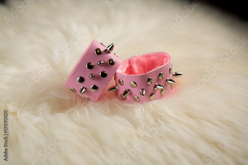pink handcuffs with thorns lie on a table