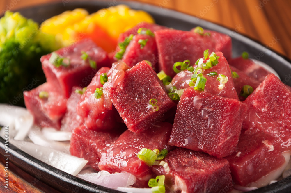 Raw cutting beef with vegetables on wooden plate Raw cutting beef with vegetables on wooden plate