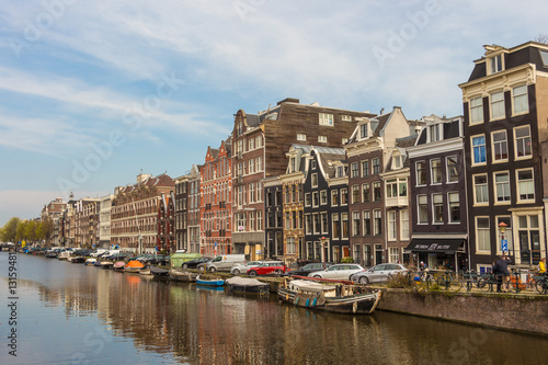 AMSTERDAM, Netherlands - APRIL 13, 2016: View from bridge to canal with typical dutch houses in Amsterdam, Netherlands