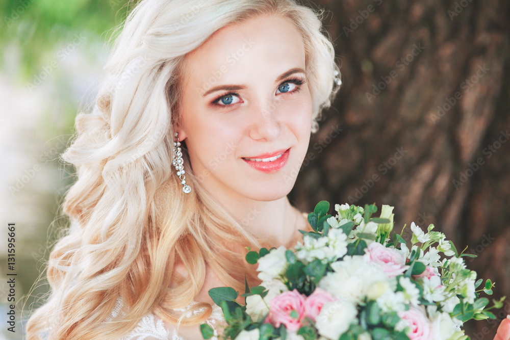 Beautiful bride. Wedding hairstyle and make up.Young bride in wedding dress holding bouquet Beautiful bride. Wedding hairstyle and make up.Young bride in wedding dress holding bouquet