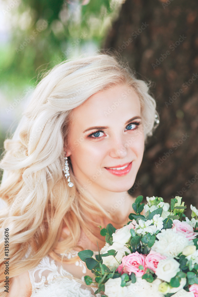 Beautiful bride. Wedding hairstyle and make up.Young bride in wedding dress holding bouquet Beautiful bride. Wedding hairstyle and make up.Young bride in wedding dress holding bouquet