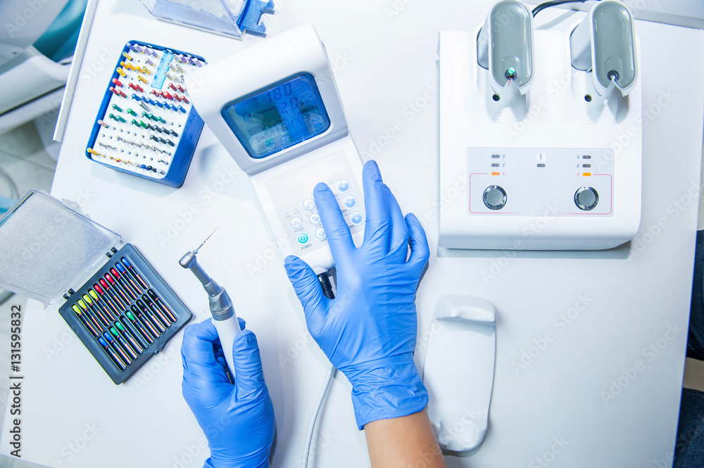 Assistant's hands configures dental equipment in dentist's office. Close up, selective focus. Dentistry Assistant's hands configures dental equipment in dentist's office. Close up, selective focus. Dentistry