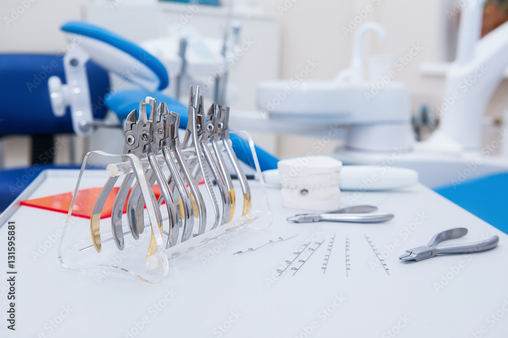 Close up Orthodontist Dental set of clamps and pliers and other tools on the working table surface