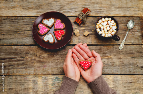 Male hands holding cookies in the forms of heart