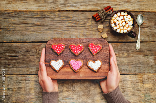 Male hands holding cookies in the forms of heart