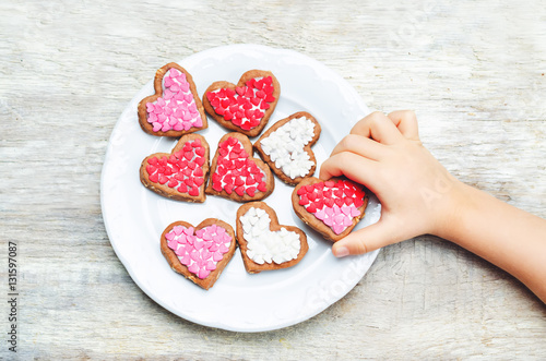 Children's hands holding cookie in the forms of heart