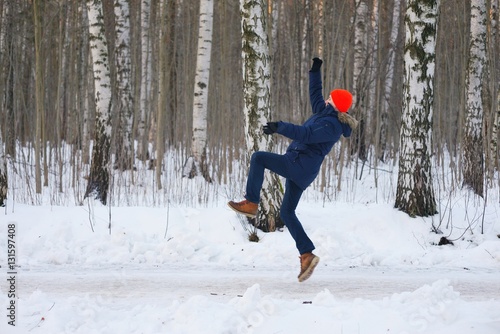 A young active person, athletic jump and swing her arms while Jogging on a birch grove in winter. photo