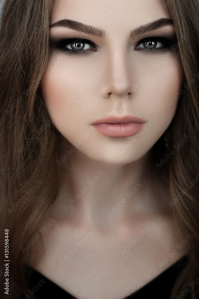 Young girl with long beautiful hair and smoky eyes wearing black maxi evening dress. Studio shot Young girl with long beautiful hair and smoky eyes wearing black maxi evening dress. Studio shot