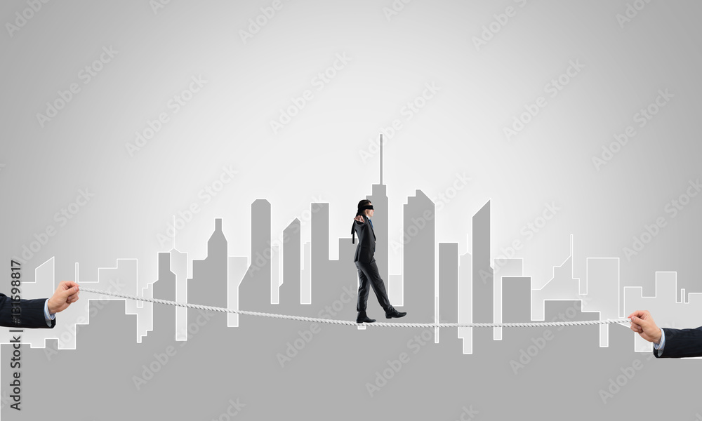 Business concept of risk support and assistance with man balancing on rope Business concept of risk support and assistance with man balancing on rope