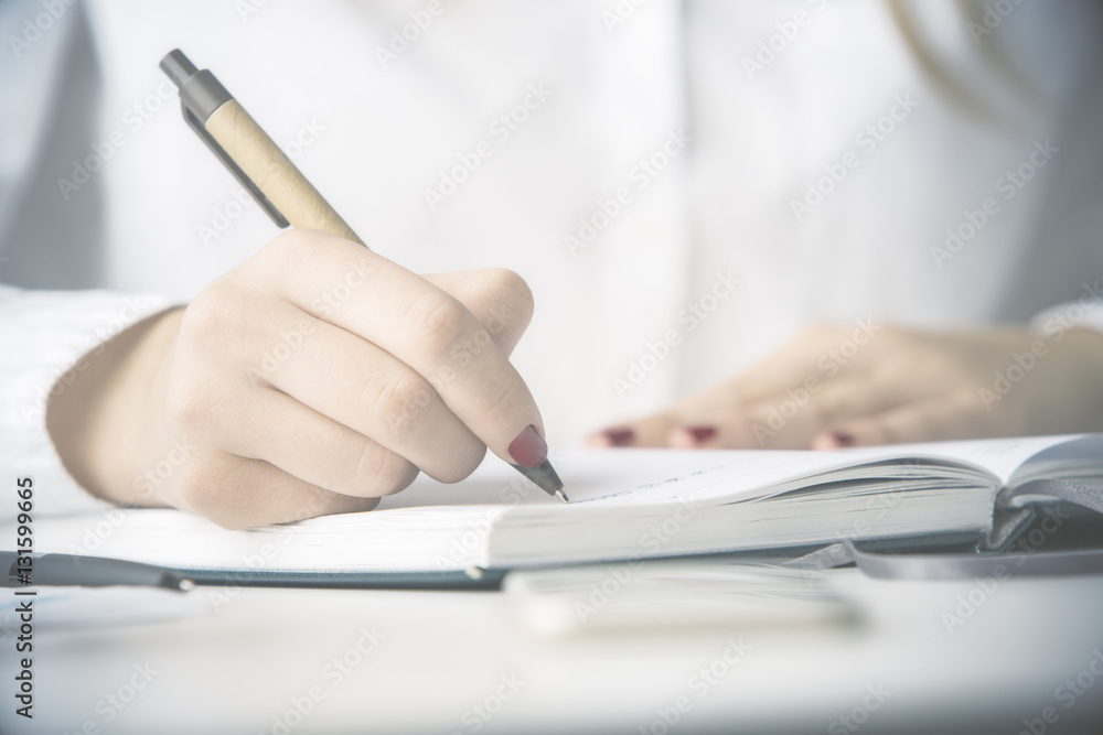 Female writing in notepad Female writing in notepad