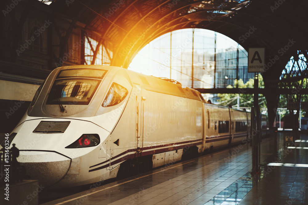 Fototapeta premium Modern contemporary white train with acuminate face at the station of Barcelona, Spain, sunny summer day