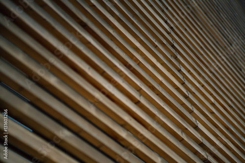 Close-up view of facade of modern building in Barcelona made by thick wooden stripes, sunny summer day, Spain