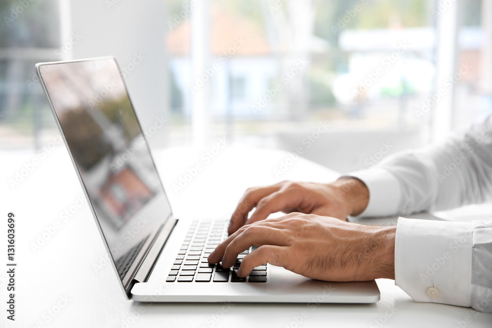 Male hands typing on laptop at office Male hands typing on laptop at office