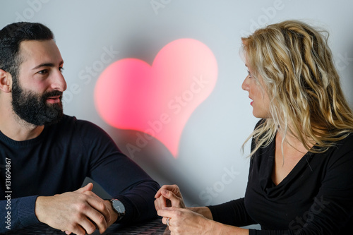 happy couple  sit on bar table   smiling and sharing good emotio photo