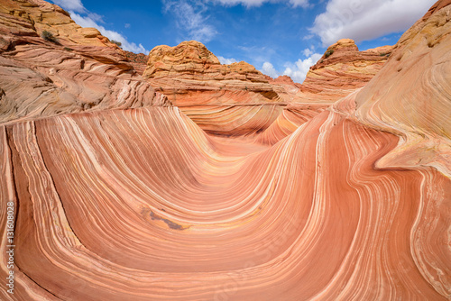 The Wave - Sunny midday view of The Wave, a dramatic erosional sandstone rock formation located in North Coyote Buttes area of Paria Canyon-Vermilion Cliffs Wilderness, at Arizona-Utah border.