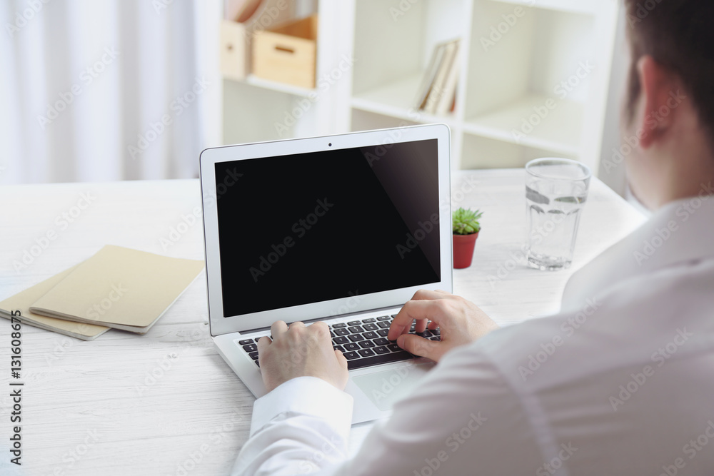 Businessman working on laptop indoors Businessman working on laptop indoors