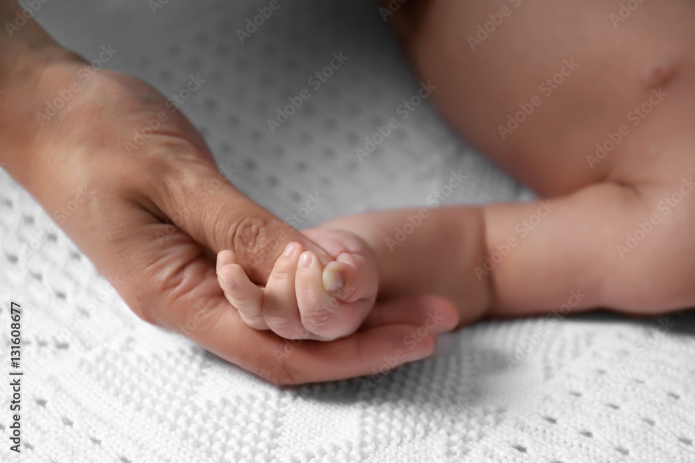 Woman holding cute small baby hand, closeup Woman holding cute small baby hand, closeup